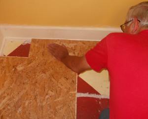 Dick laying a trimmed piece of tile.